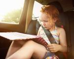 Kind mit Tablet im Auto - Laut einer Umfrage verbringen rund Dreiviertel aller Kinder auf langen Autofahrten viele Stunden an Handy oder Tablet.