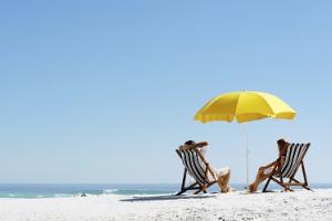 Pärchen am Strand mit gelbem Sonnenschirm