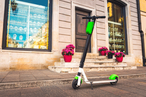 Ein E-Scooter steht in einer Stadt vor einem Schaufenster.