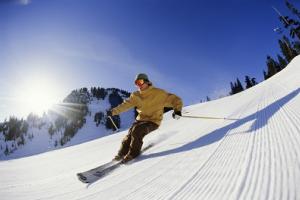 Mann fährt Ski auf einer Piste.