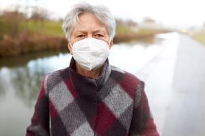 An Flughäfen und im Flugzeug müssen ab 1. Februar medizinische oder FFP2-Masken getragen werden. Seniorin mit FFP2-Maske beim Spaziergang