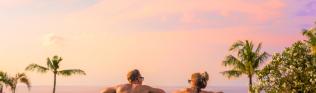 Paar im Pool bei Sonnenuntergang
