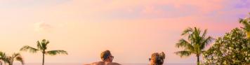 Paar im Pool bei Sonnenuntergang