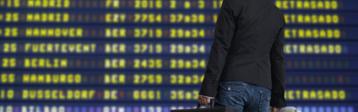 Reisende vor Anzeigetafel Flughafen