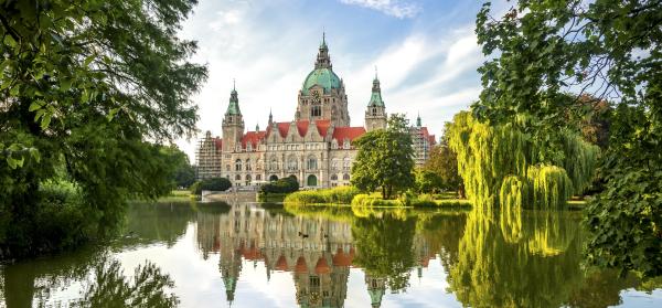 Neues Rathaus in Hannover mit Natur im Vordergrund.