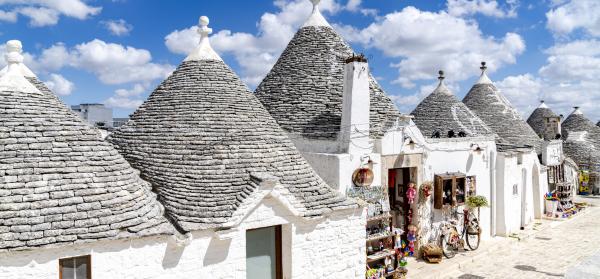 Traditionelle Trulli-Häuser in Alberobello mit konischen Steindächern unter blauem Himmel