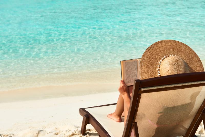 Frau liest am Strand