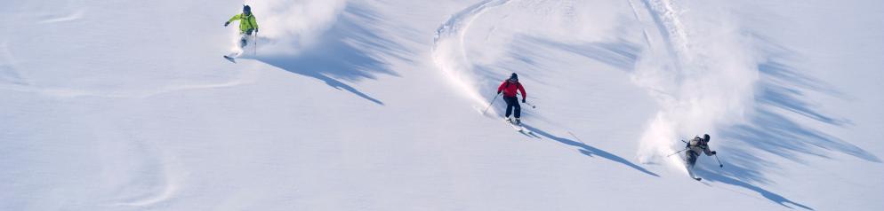 Drei Menschen fahren Ski