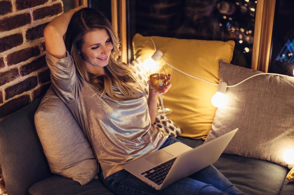 Sonstiges: Frau mit Laptop und Wein - Urlaubsplanung